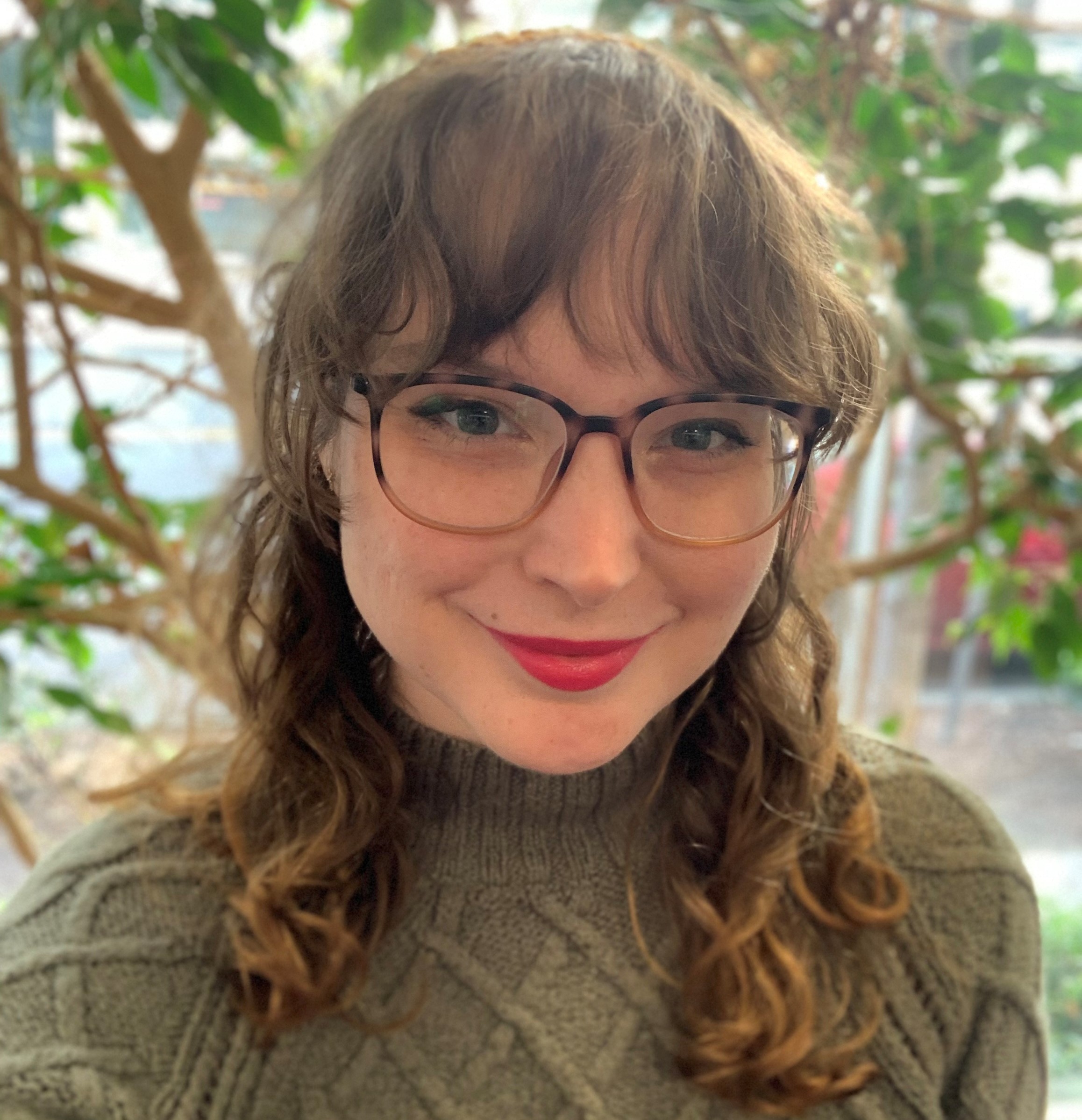 Headshot of Erin Groth in front of a plant.