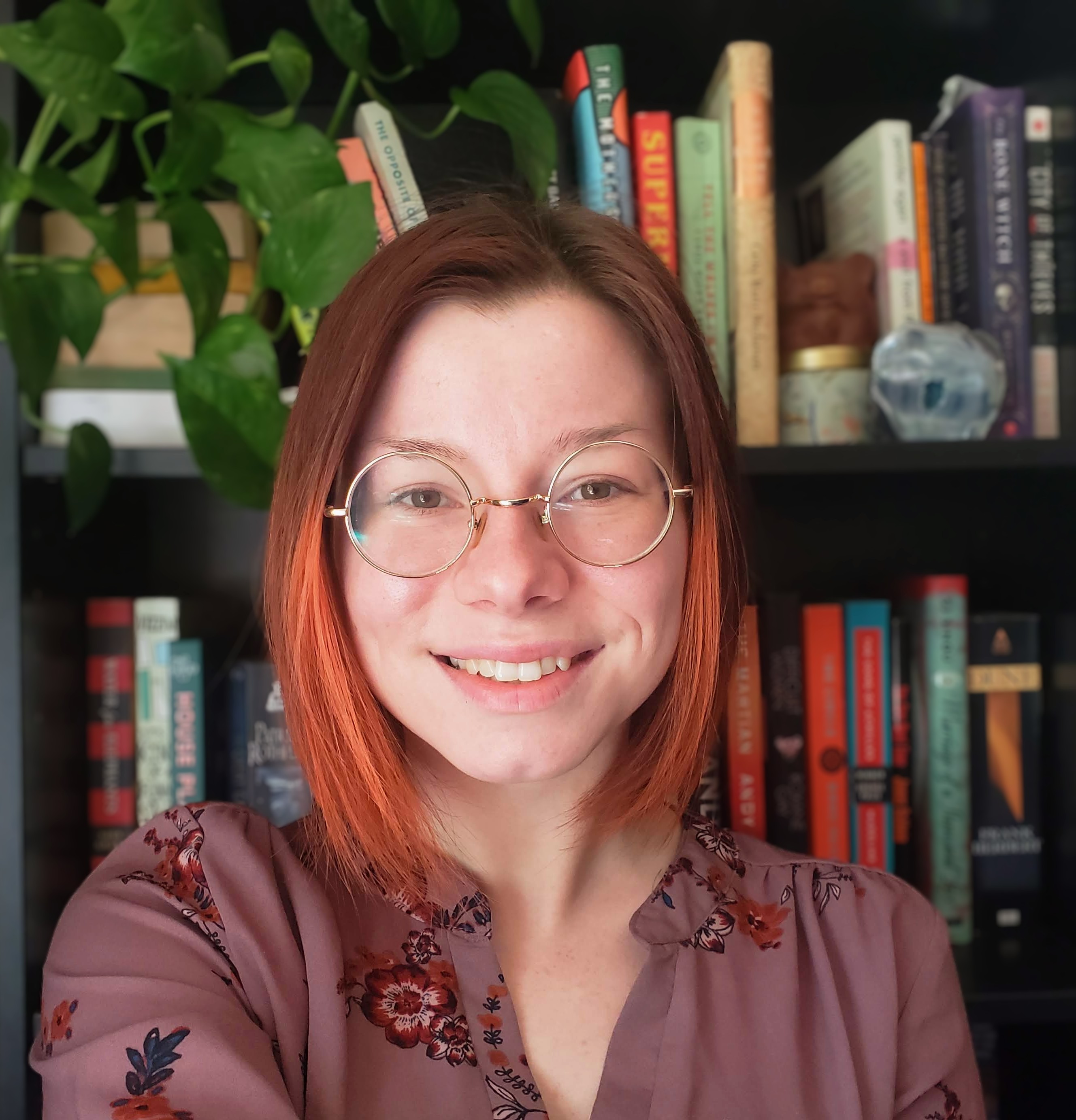 Woman posing in front of a bookcase.